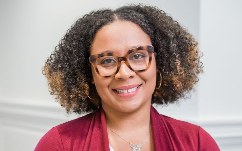 Andrea Robinson is sitting and smiling at the camera