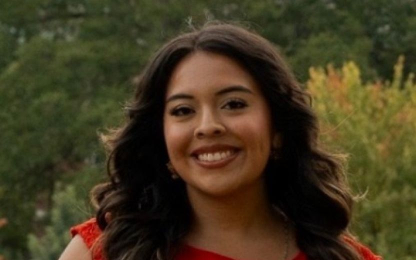 Mariah Chavez is smiling at the camera and is outdoors