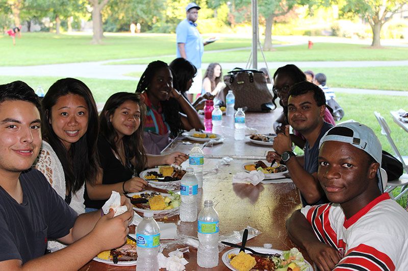 Students gathered around a long table at the Fall 2014 BBQ