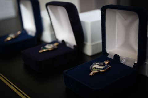 : Photo of three blue and gold Chi Alpha Epsilon jewelry pin in individual blue Jewlery boxes
