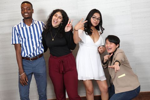 Four students smiling and laughing together at the EOP/HEOP 50th Anniversary Celebration in the Statler Ballroom in October 2019