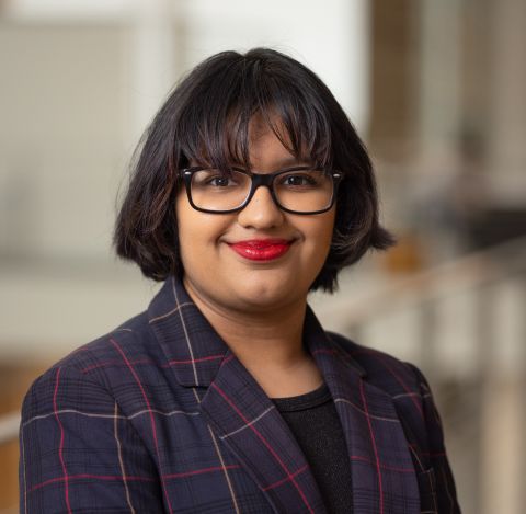 Ariel Marxena Baksh is smiling at the camera. She has on a business suit