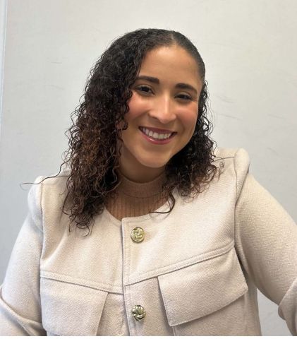 Alyanis Acevedo Serrano is smiling at the camera and wearing a beige blazer.