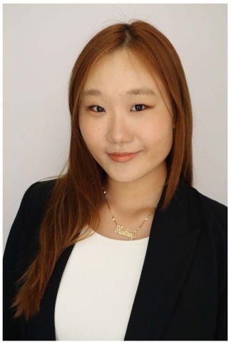 Aubrey Im is smiling at the camera. She has a black blazer over a white shirt