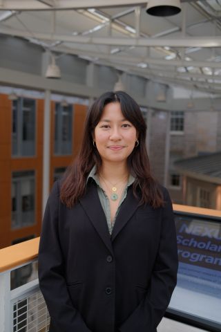 Ashley Bax is smiling at the camera.