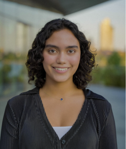 Giselle G is outside on a sunny day and smiling at the camera