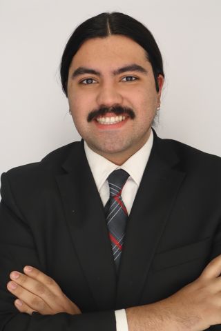 Zelazzie Zepeda is smiling at camera in a business suit