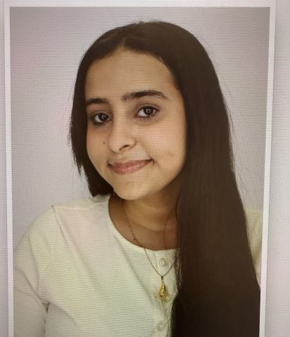 Halimah Hotbani is looking at the camera. She is wearing a white shirt