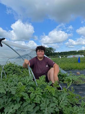 Olga Khmelnitsky is outside watering a field of crops